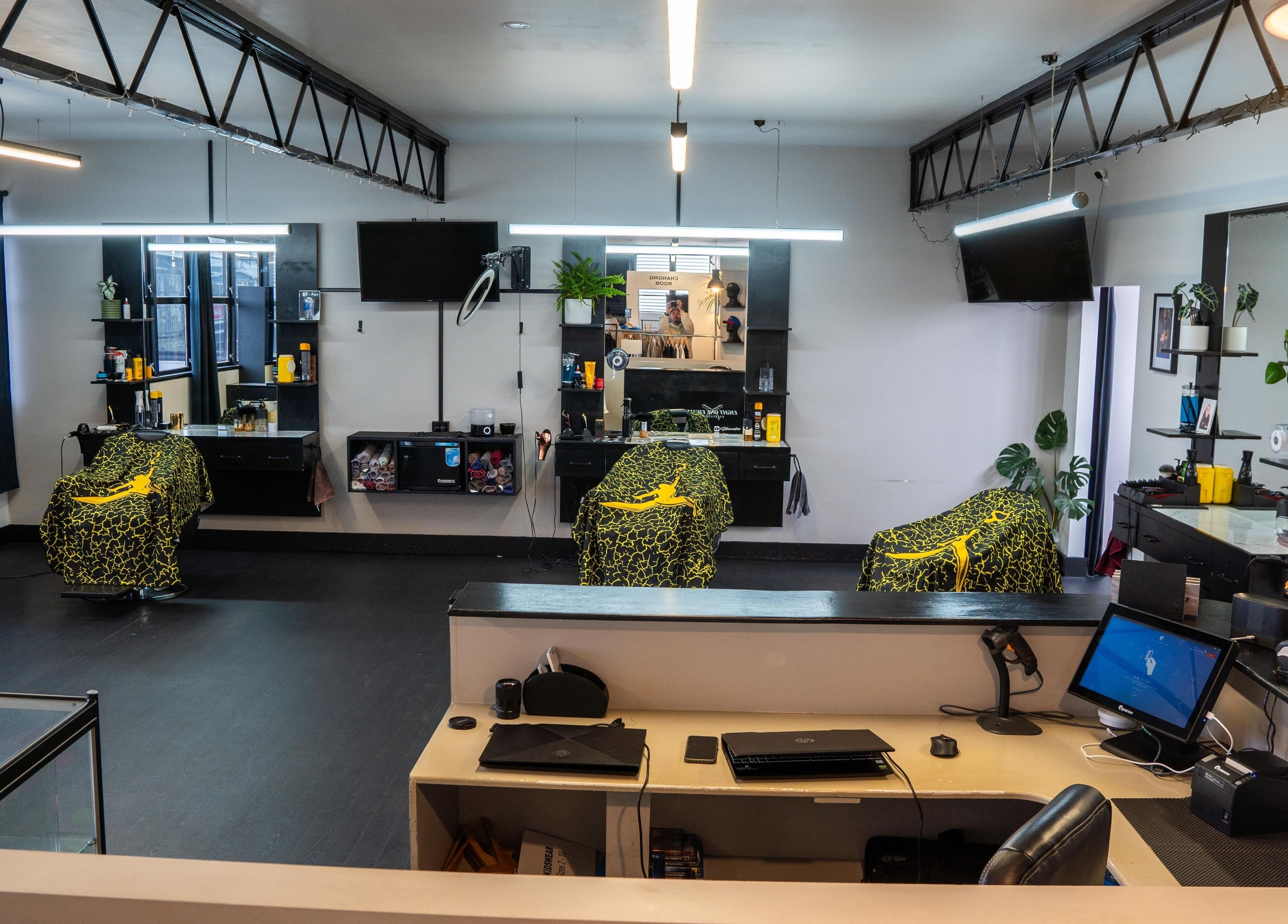 Modern interior of Eight One Eight Barbershop, Auckland, NZ, featuring stylish barber chairs and mirrors.