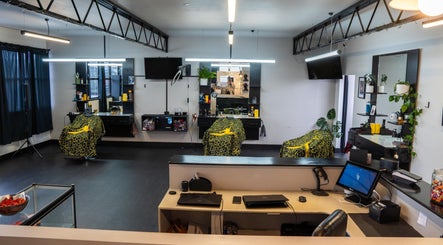 Modern interior of Eight One Eight Barbershop, Auckland, NZ, featuring stylish barber chairs and mirrors.