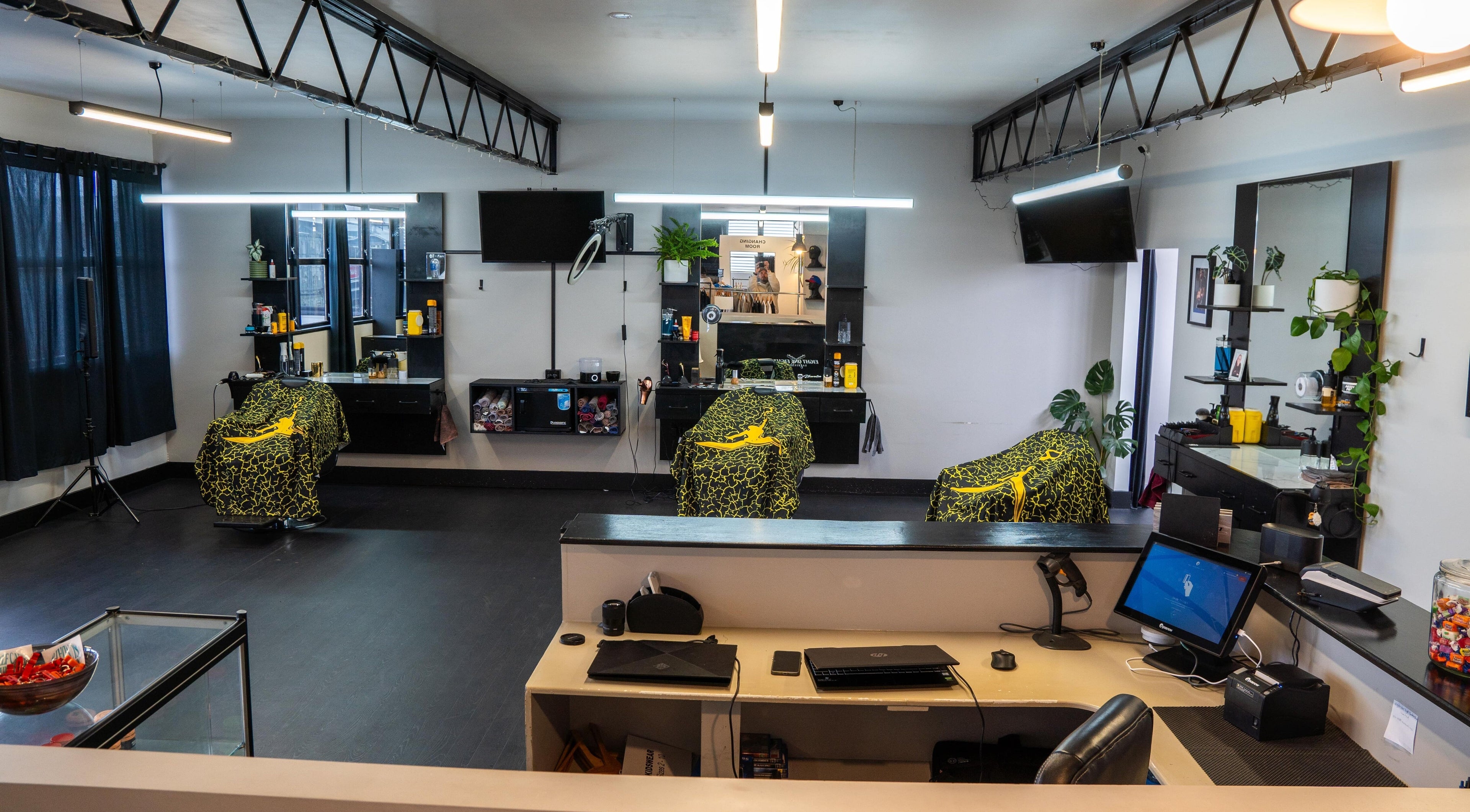 Modern interior of Eight One Eight Barbershop, Auckland, NZ, featuring stylish barber chairs and mirrors.