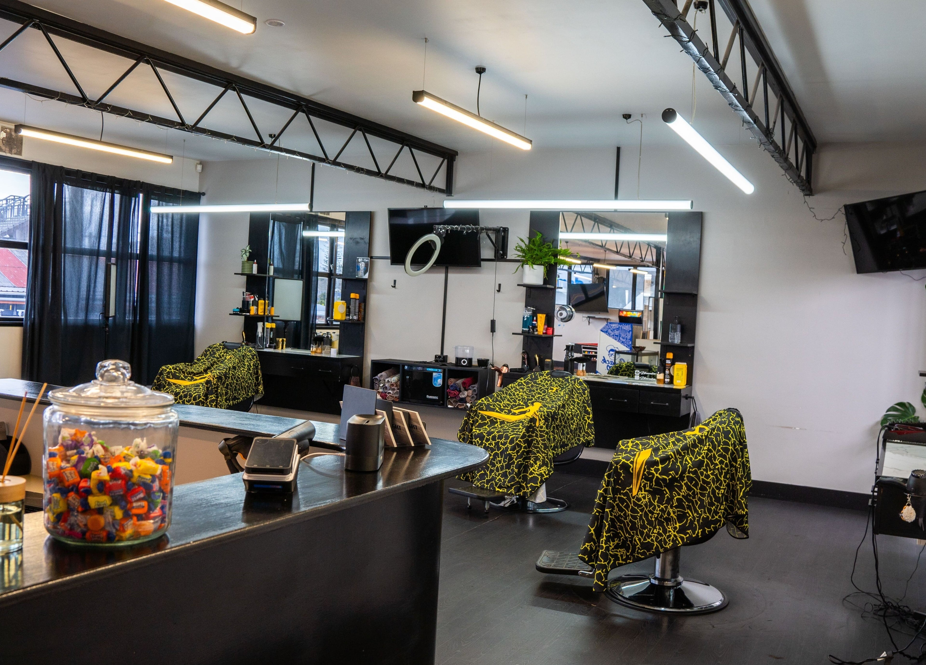 Interior of Eight One Eight Barbershop in Auckland, NZ, featuring modern styling chairs and sleek decor.