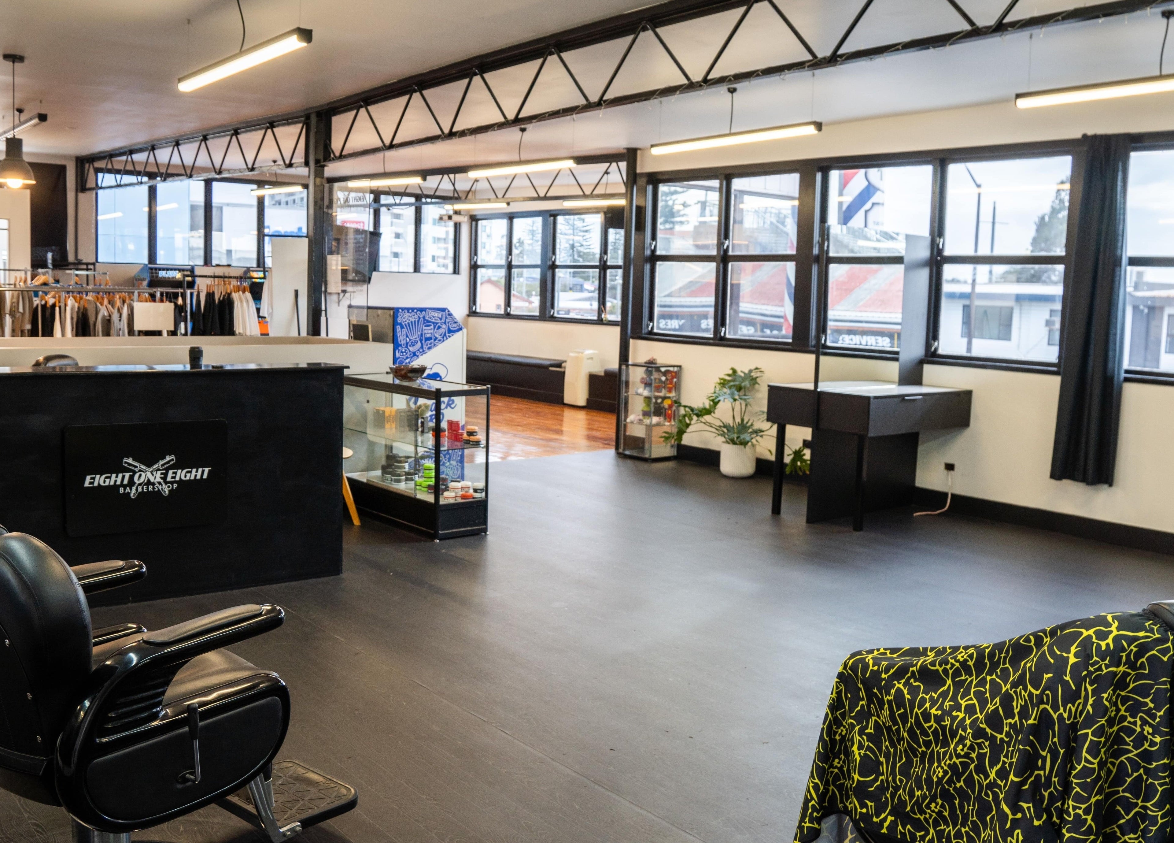 Sleek interior of Eight One Eight Barbershop, Auckland, Auckland, NZ with modern decor and bright lighting.
