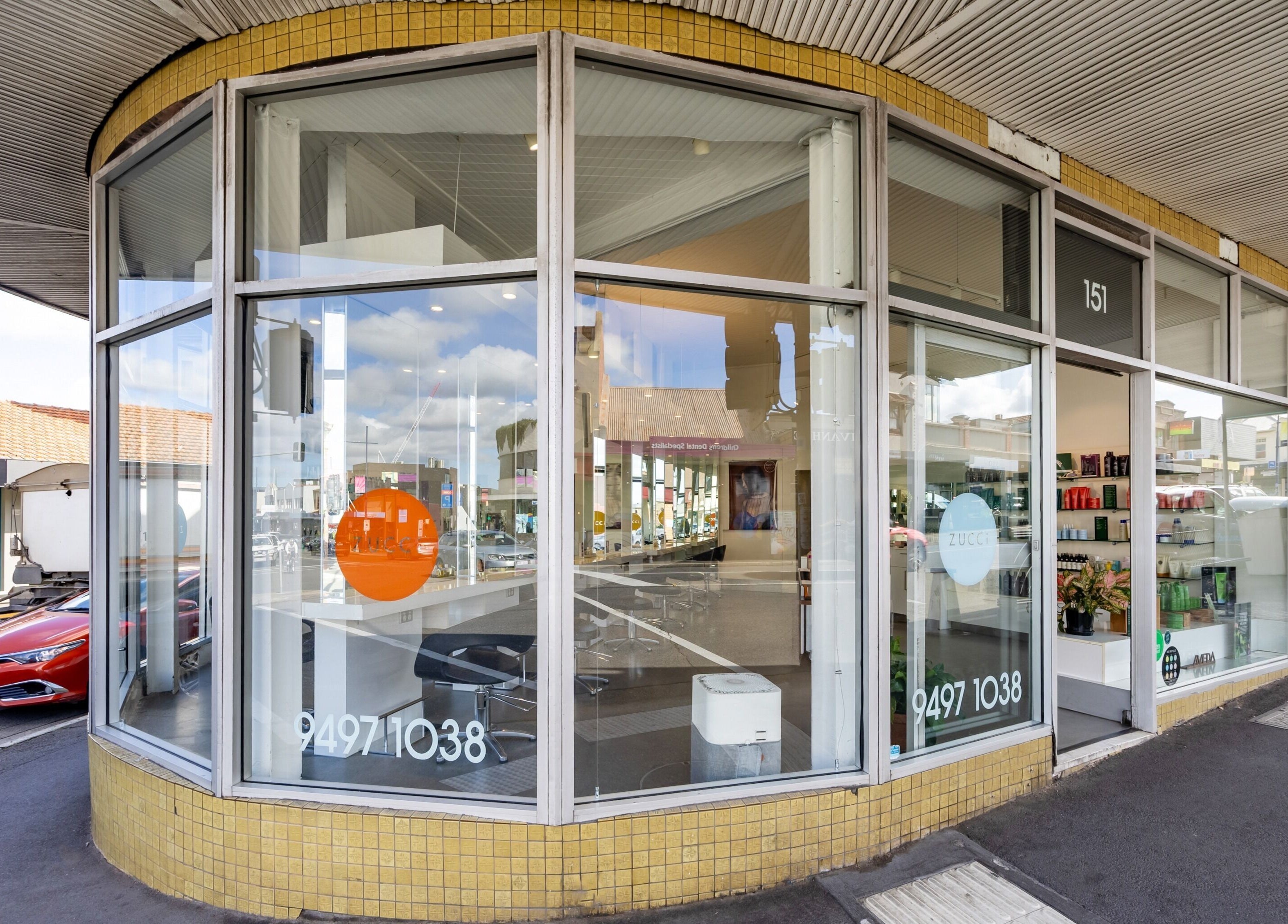 Street view of Zucci Ivanhoe in Melbourne, Victoria, AU, showcasing modern glass-fronted beauty salon.