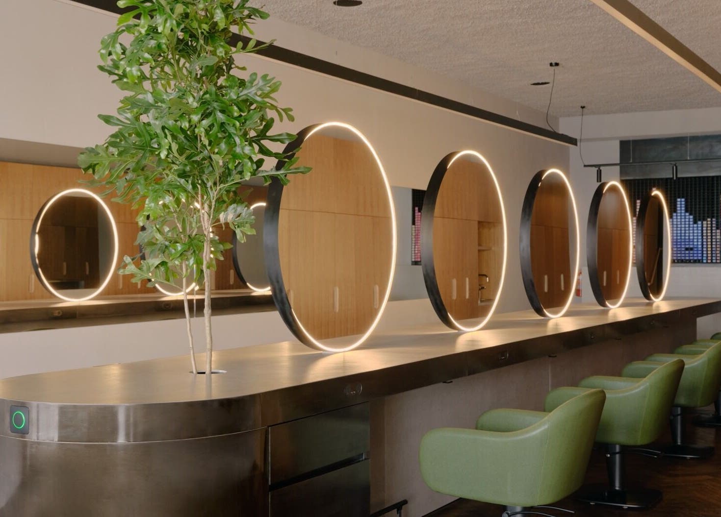 Modern salon interior with stylish round mirrors and green chairs at Zucci South Melbourne, Melbourne, Victoria, AU.