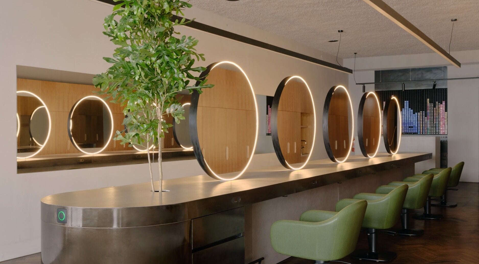Modern salon interior with stylish round mirrors and green chairs at Zucci South Melbourne, Melbourne, Victoria, AU.