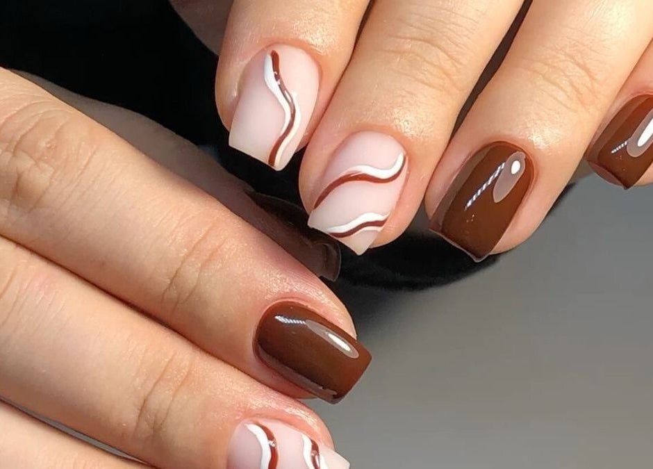 Elegant brown and white swirl nails design at Dolled Beauties & Gents, ZA, showcasing expert styling.