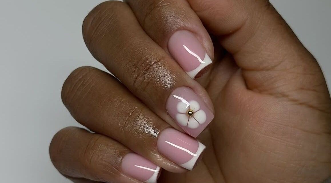 Elegant pink and white nail art with a floral design at Dolled Beauties & Gents, ZA.