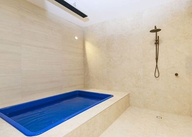 Luxurious bathing area at Excelsius Wellness, Forest Glen, Queensland, AU, featuring a sleek blue tub.