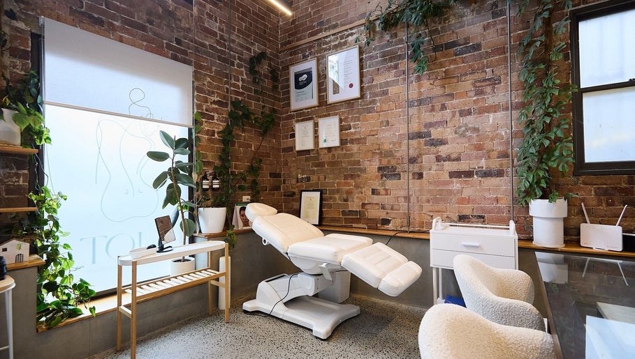 Relaxing treatment room at Nurse Amy Aesthetics, Paddington, New South Wales, AU with lush greenery and certificates.
