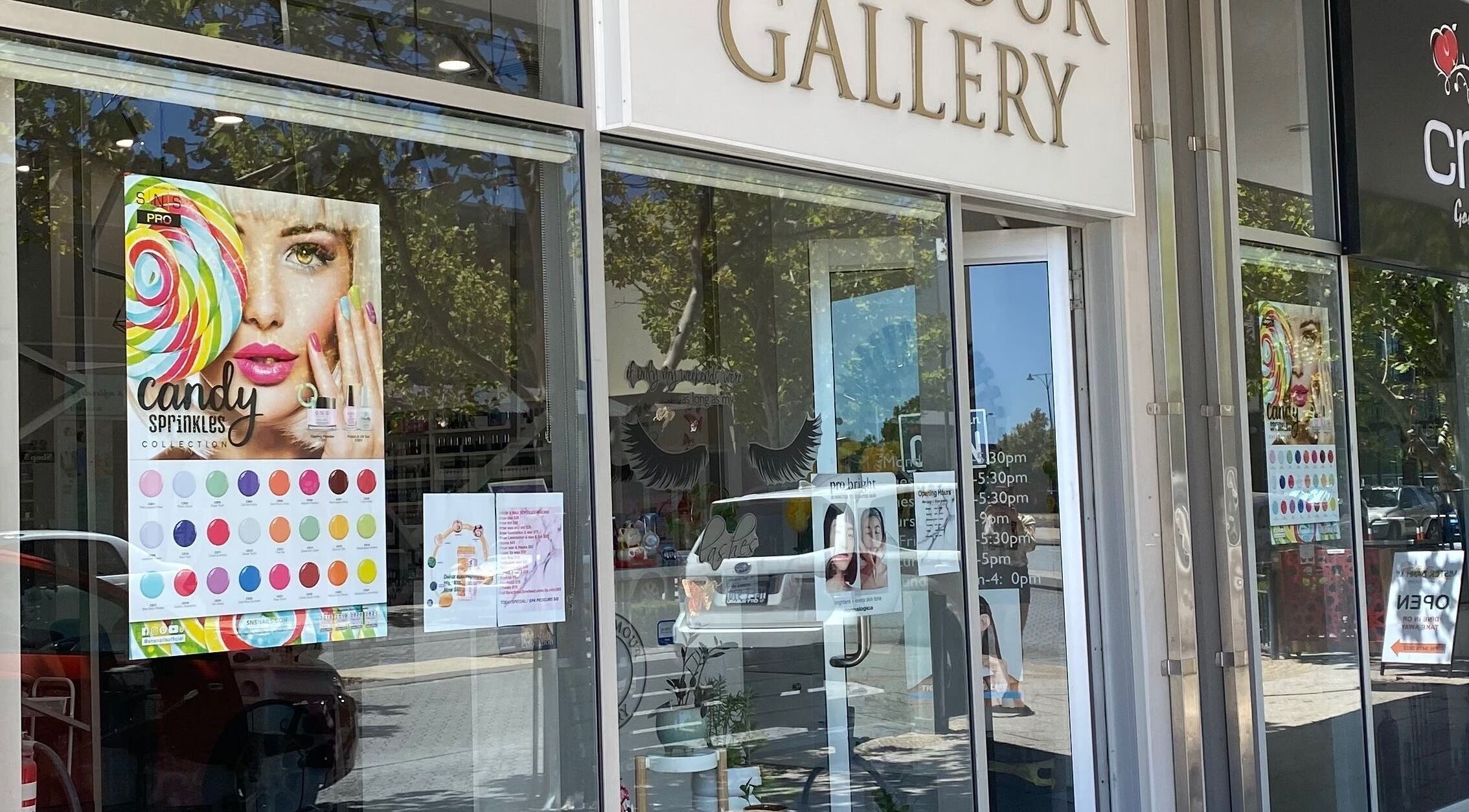 Entrance of The Glamour Gallery in Ellenbrook, Western Australia, AU showcasing colorful promotional posters.