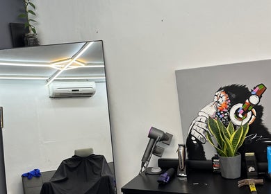 Modern interior of Nul’s Barbershop in Batu Caves, Selangor, MY with stylist tools and vibrant artwork.