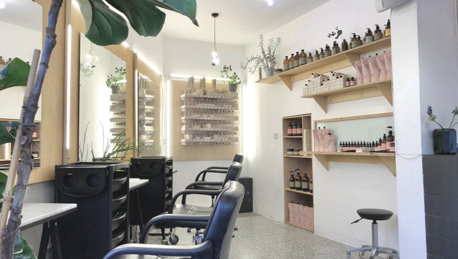 Bright interior of Onics Hair salon, featuring chairs and product displays in London, England, GB.