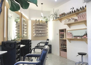 Bright interior of Onics Hair salon, featuring chairs and product displays in London, England, GB.