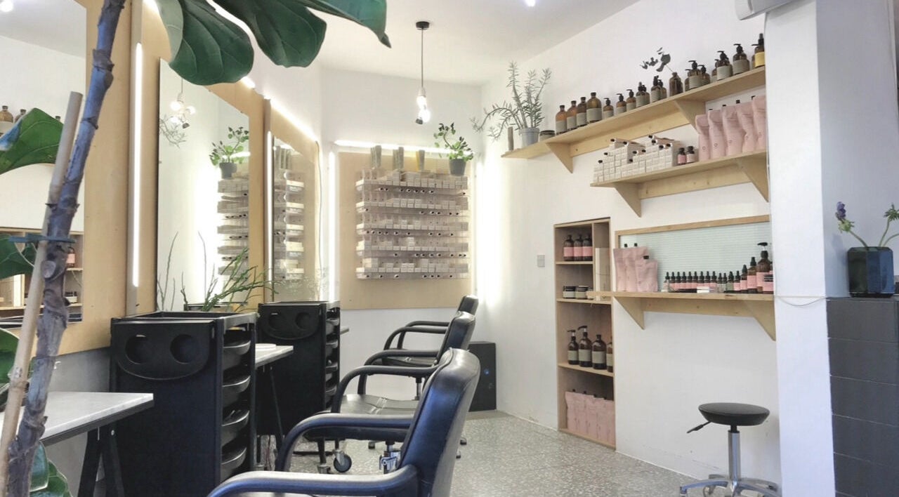 Modern interior of Onics Hair, London, England, GB, featuring sleek styling chairs and product shelves.