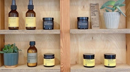 Natural hair products on wooden shelves at Onics Hair, London, England, GB. Plant decoration adds a fresh touch.
