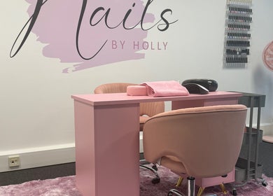 Stylish nail salon setup at Nails By Holly, Great Blakenham, England, featuring pink decor and manicure stations.