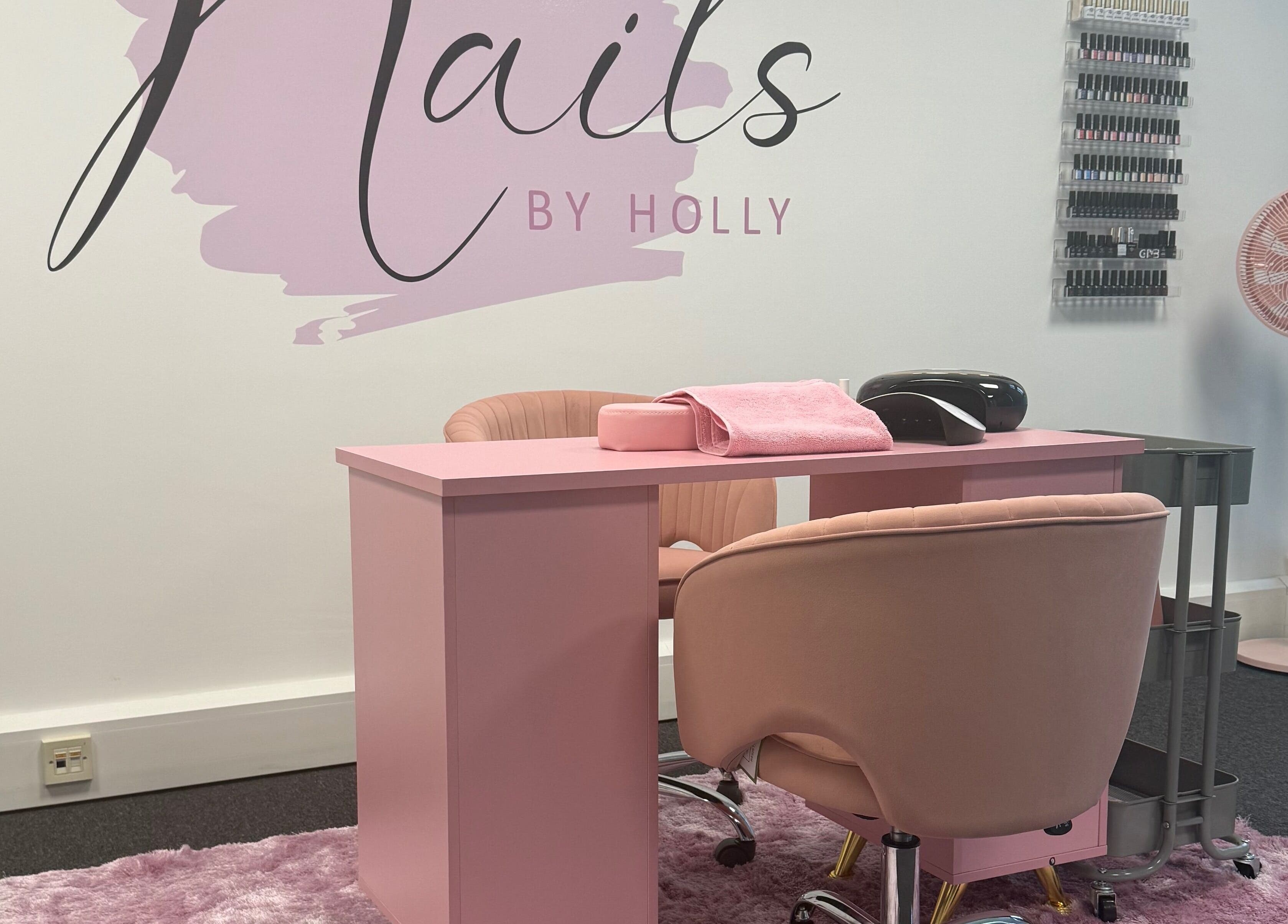 Stylish nail salon setup at Nails By Holly, Great Blakenham, England, featuring pink decor and manicure stations.