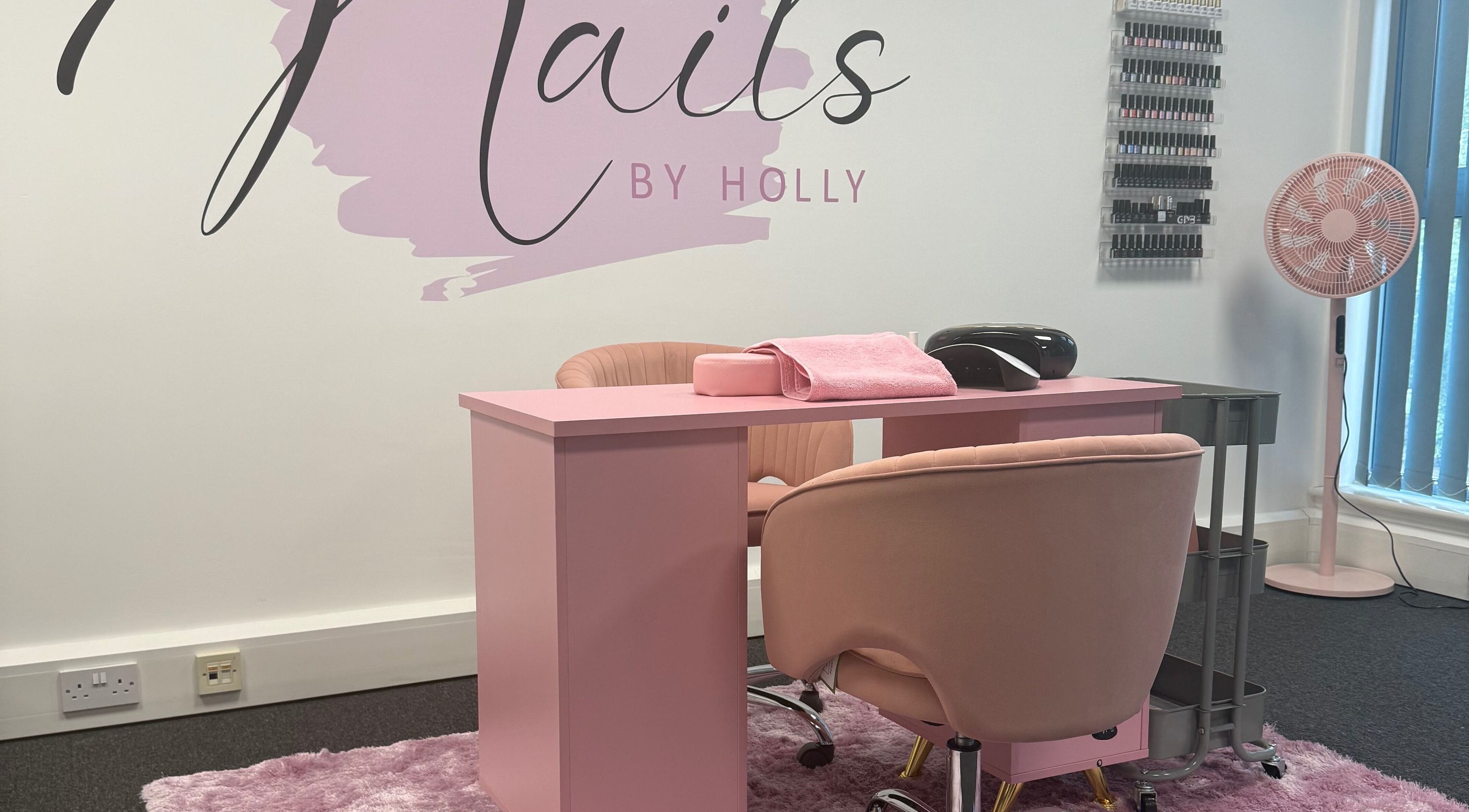 Stylish nail salon setup at Nails By Holly, Great Blakenham, England, featuring pink decor and manicure stations.