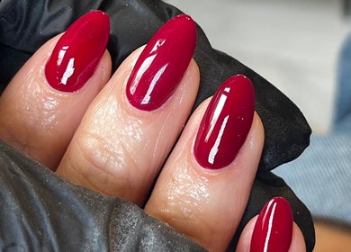 Glossed by Ell in Oldbury, England showcases vibrant red manicure on almond-shaped nails.