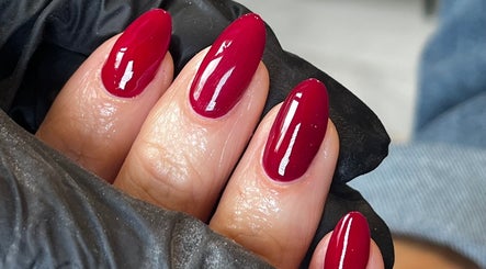 Glossed by Ell in Oldbury, England showcases vibrant red manicure on almond-shaped nails.