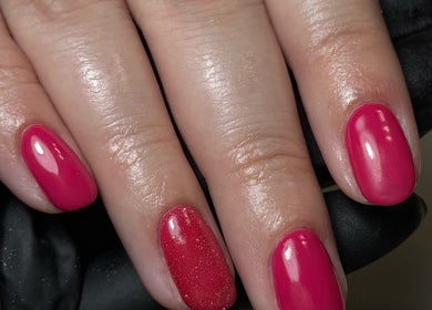 Bright pink manicure at Cured By Jess in Sandbach, England, GB showcasing glossy nail polish.