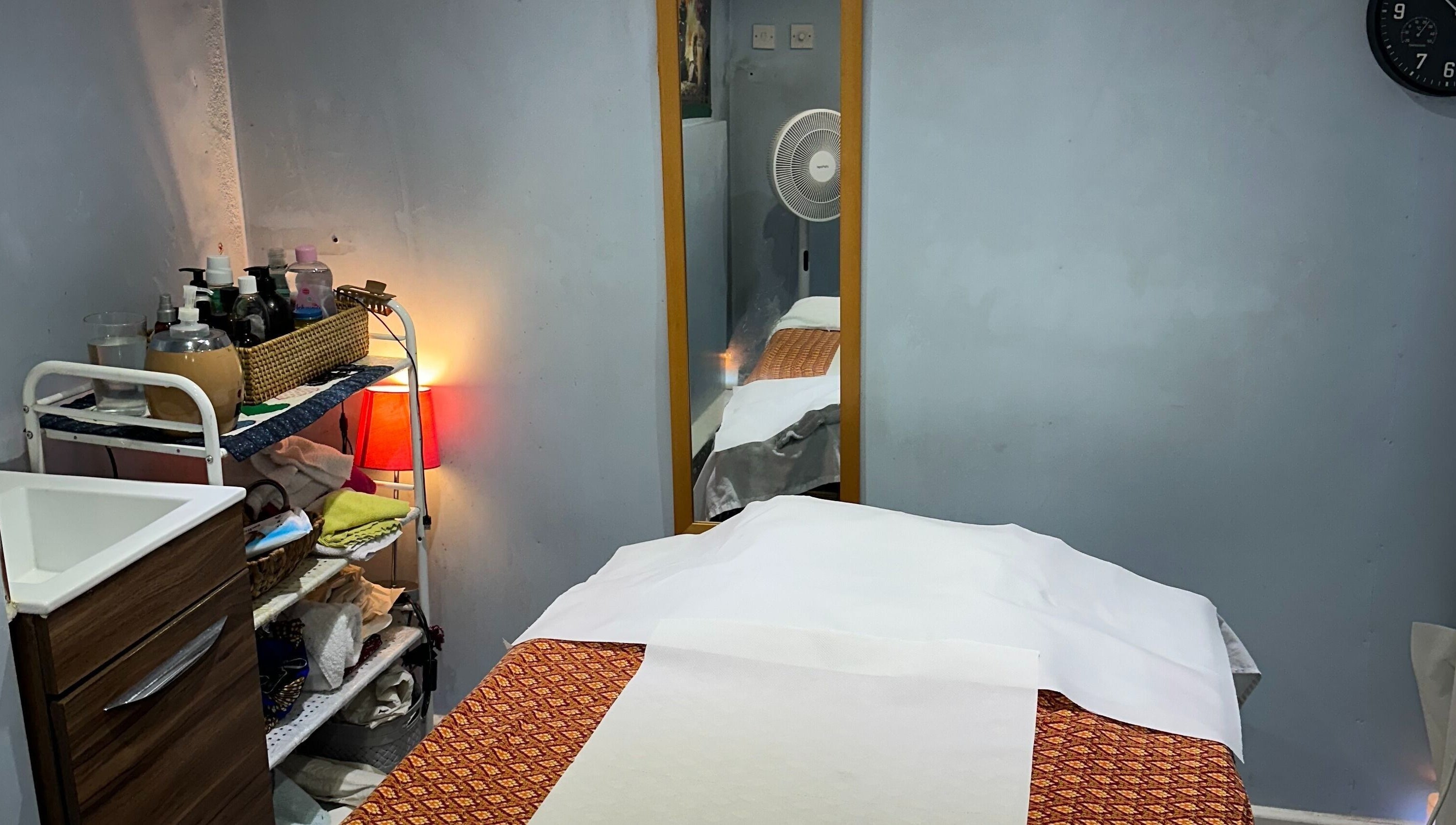Relaxing treatment room at TA Thai Massage, London, England, GB, showcasing a cozy massage table setup.