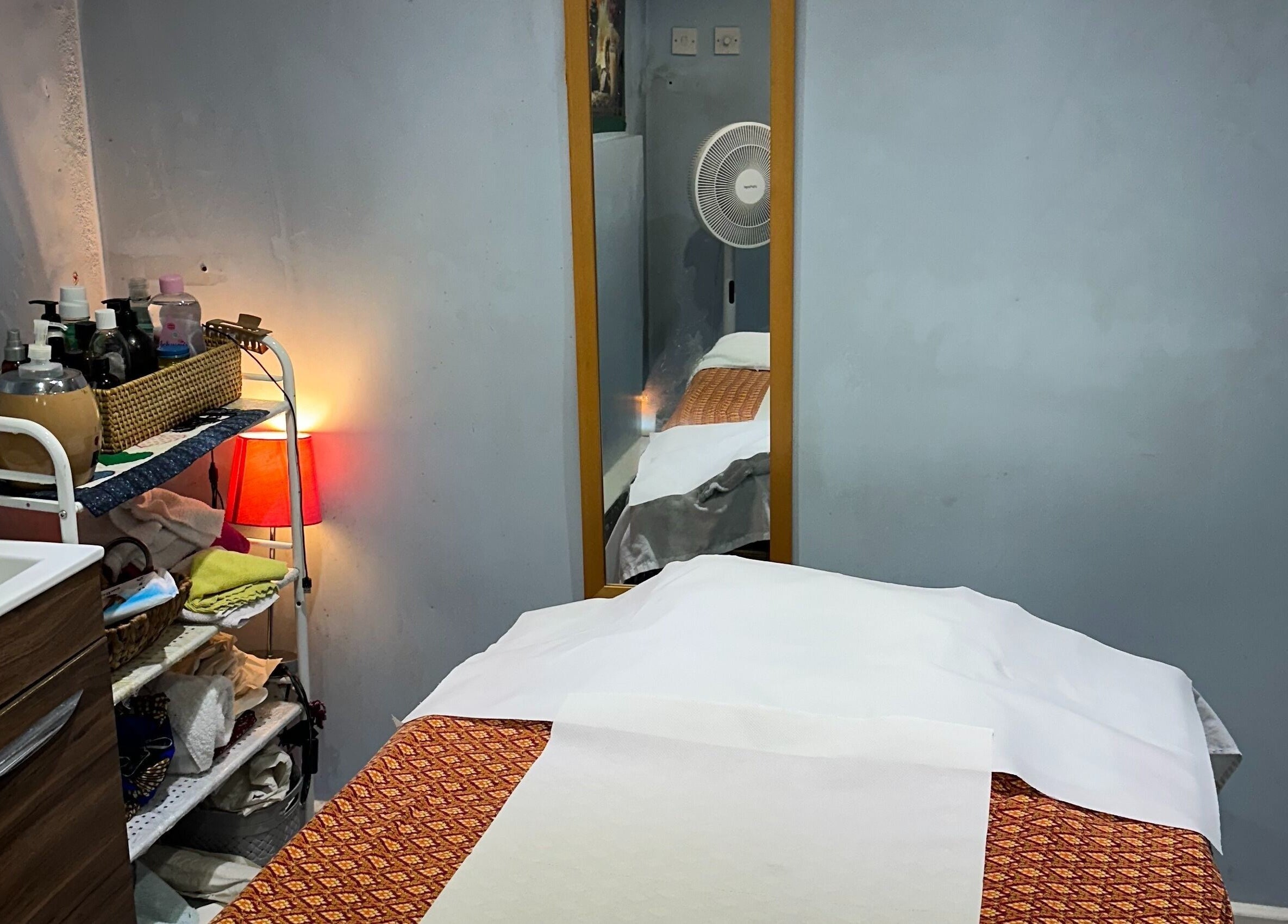 Relaxing treatment room at TA Thai Massage, London, England, GB, showcasing a cozy massage table setup.
