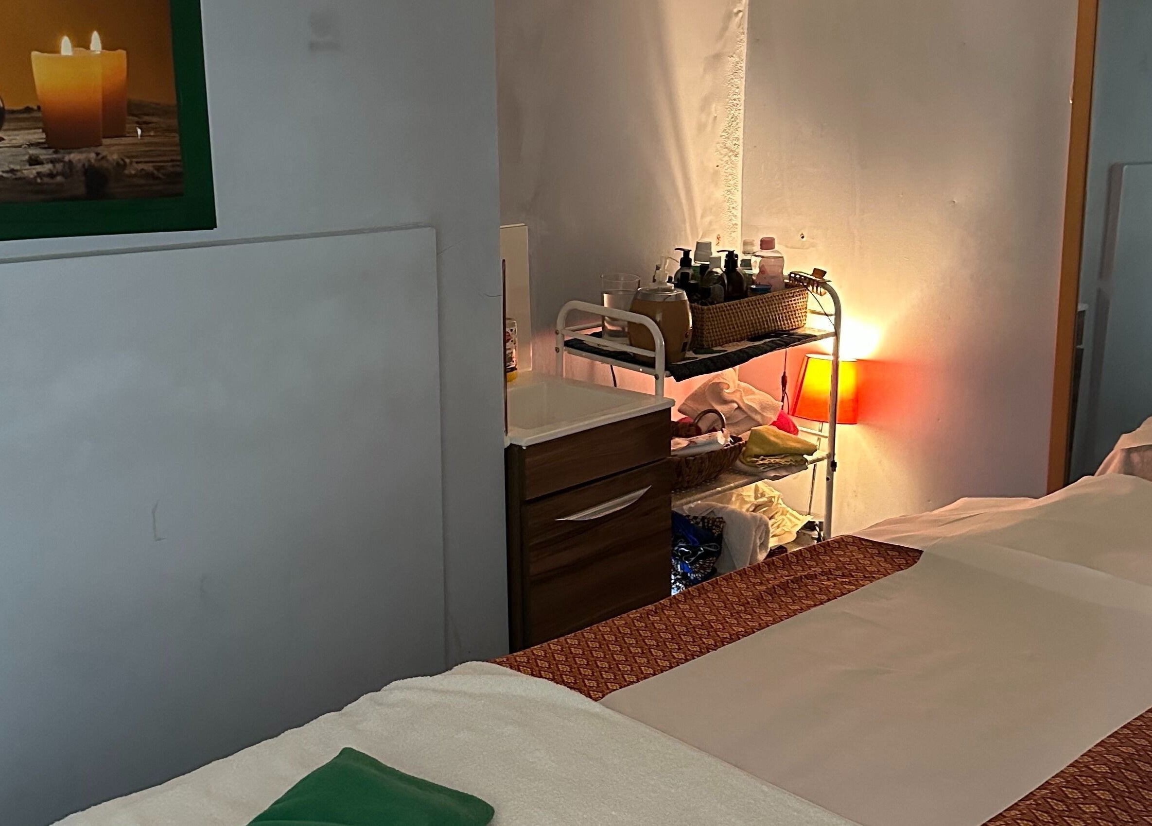 Relaxing massage room at TA Thai Massage, London, England, GB with soothing candles and cozy decor.