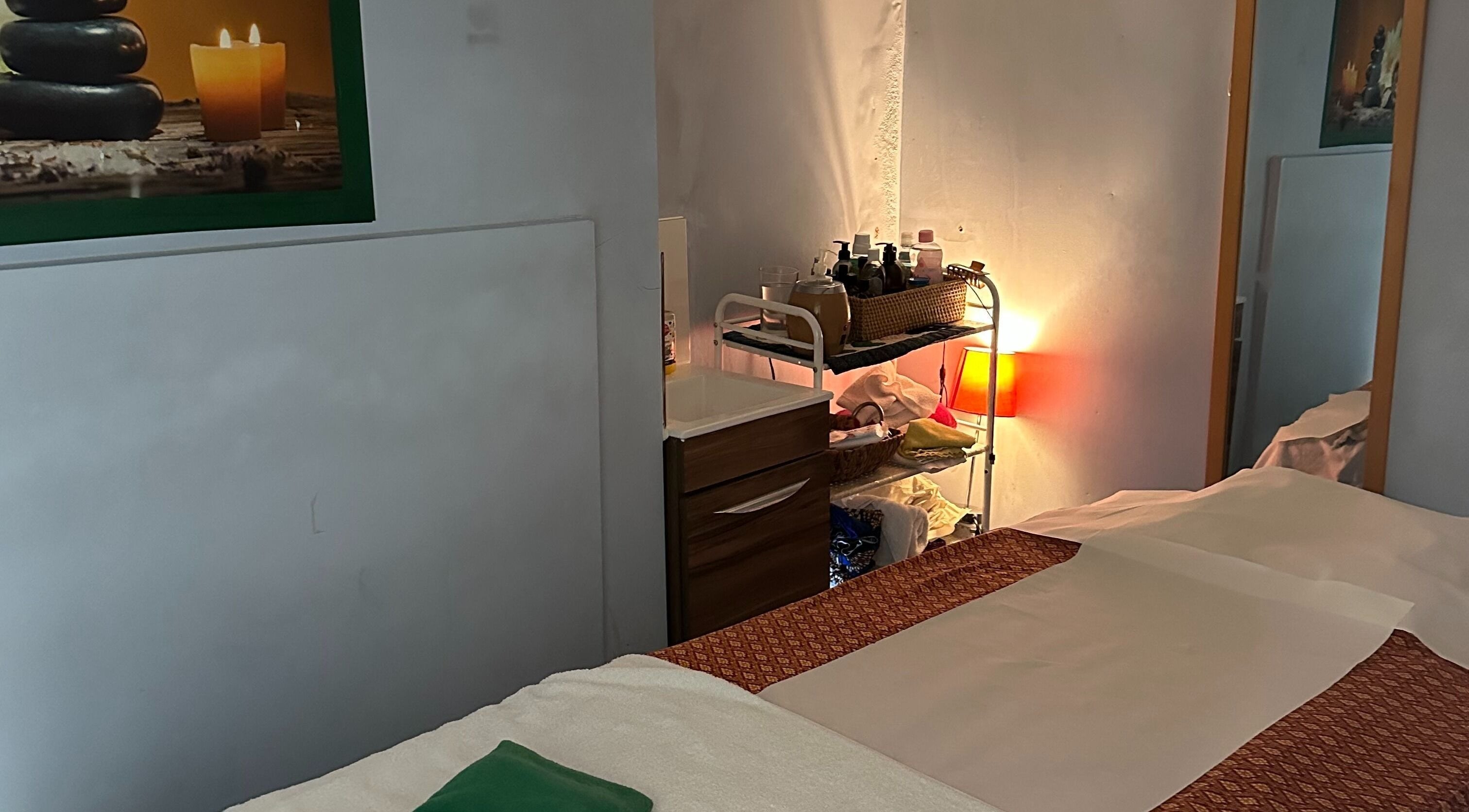 Relaxing massage room at TA Thai Massage, London, England, GB with soothing candles and cozy decor.