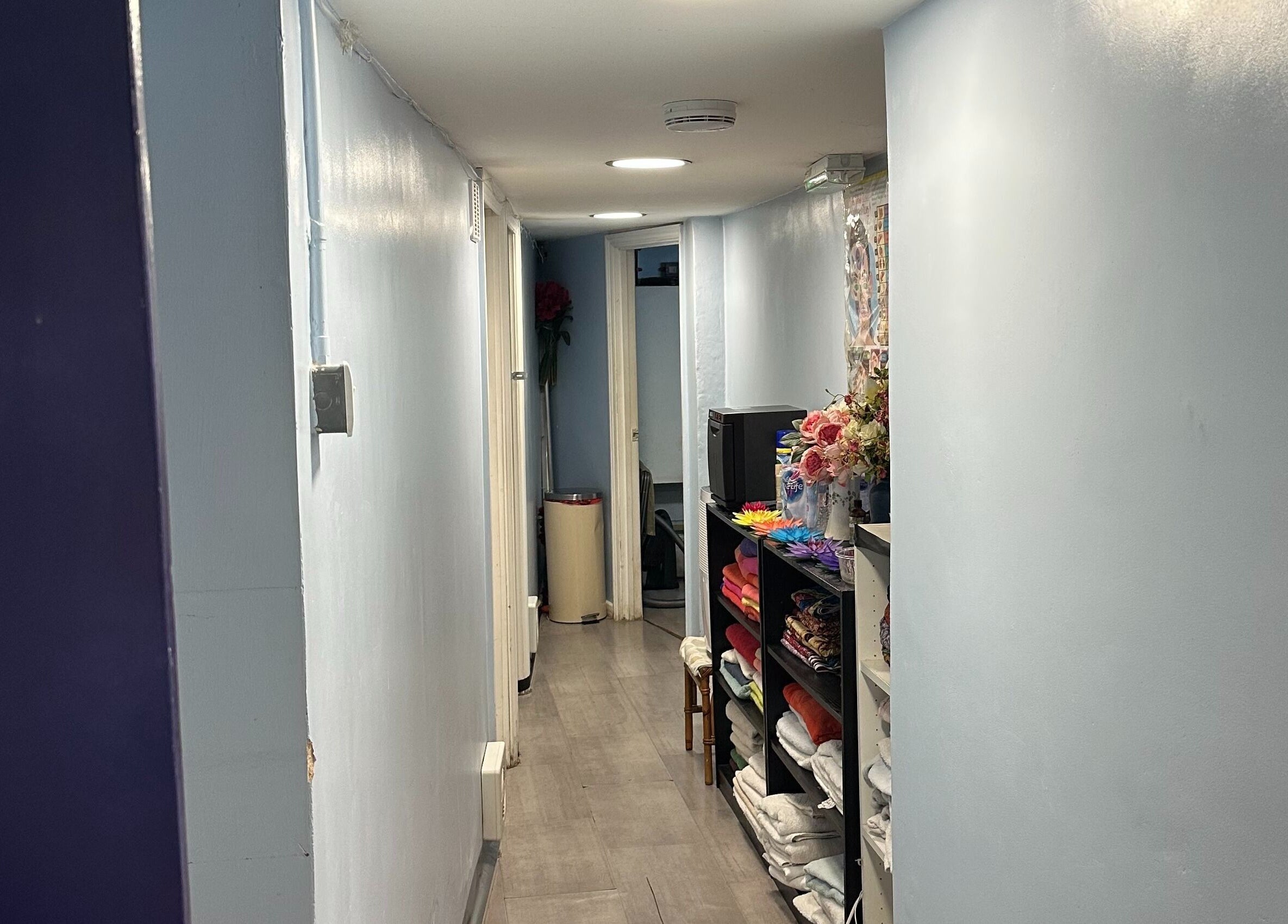 Peaceful hallway at TA Thai Massage, London, England, GB, showcasing tidy shelves and calming decor.