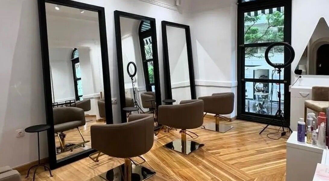 Κομψό εσωτερικό του B Exclusive στη Θεσσαλονίκη, GR με καθρέφτες και καθίσματα.