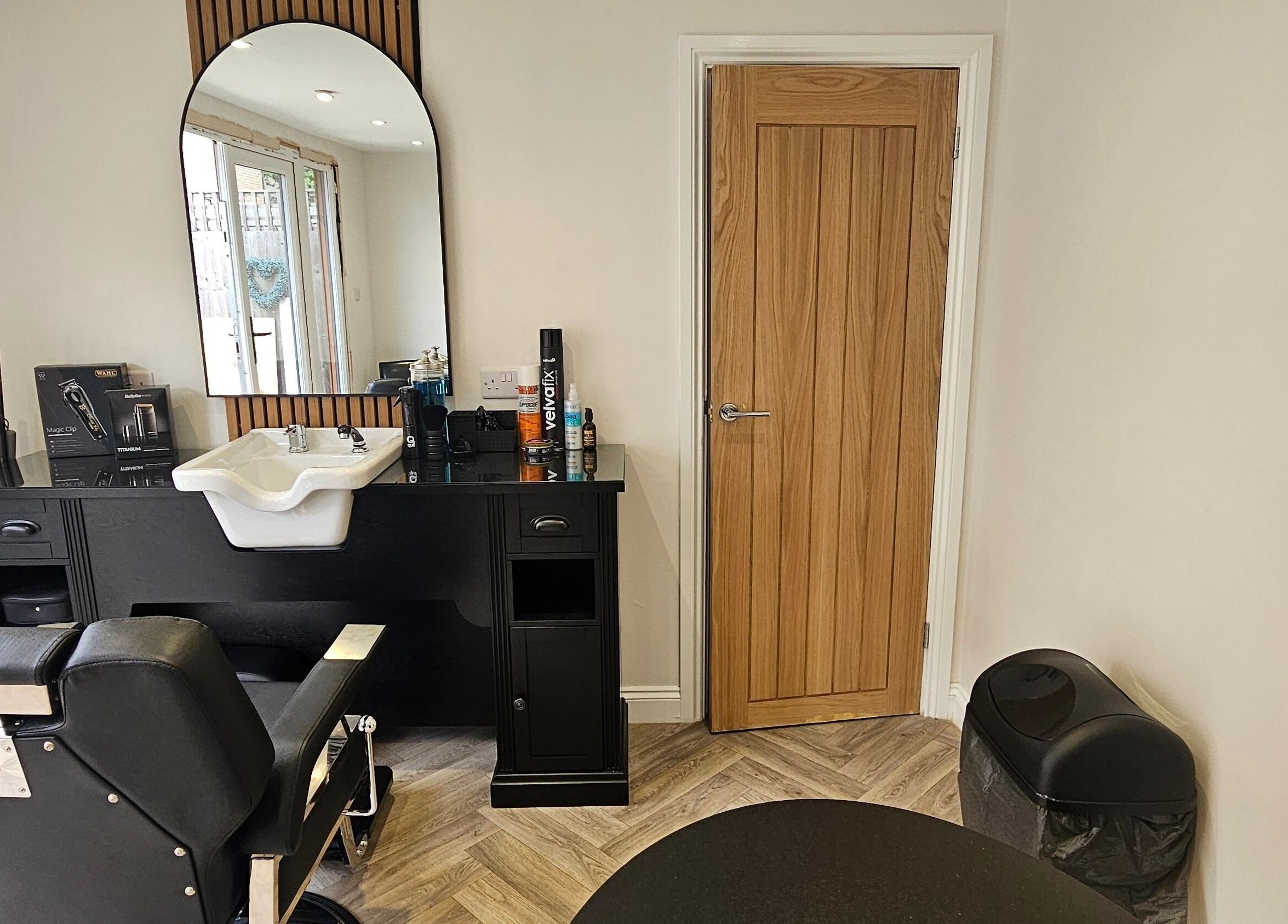 Modern barber station at The Barber Box, Sheffield, England, GB with sleek black chair and wooden accents.