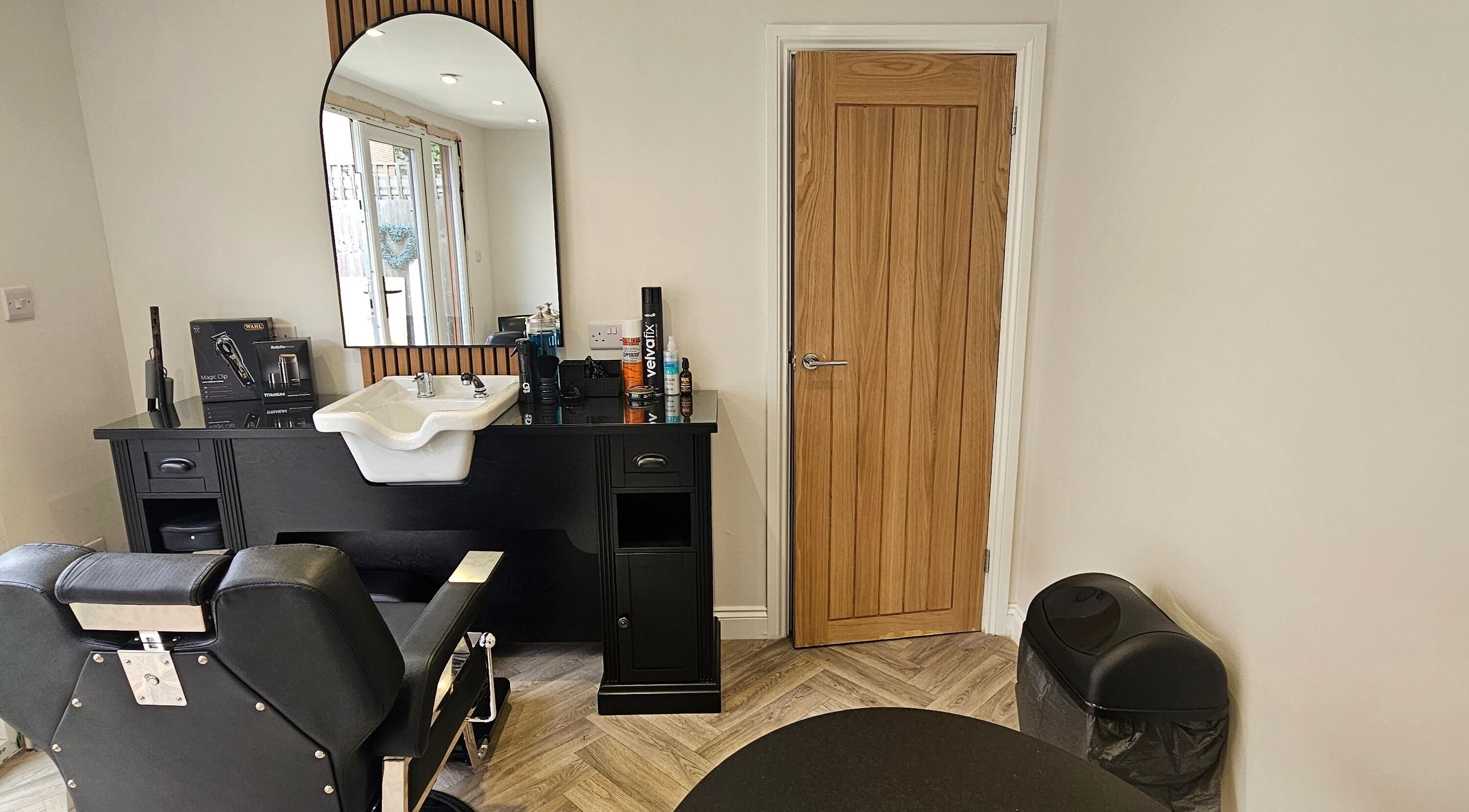 Modern barber station at The Barber Box, Sheffield, England, GB with sleek black chair and wooden accents.