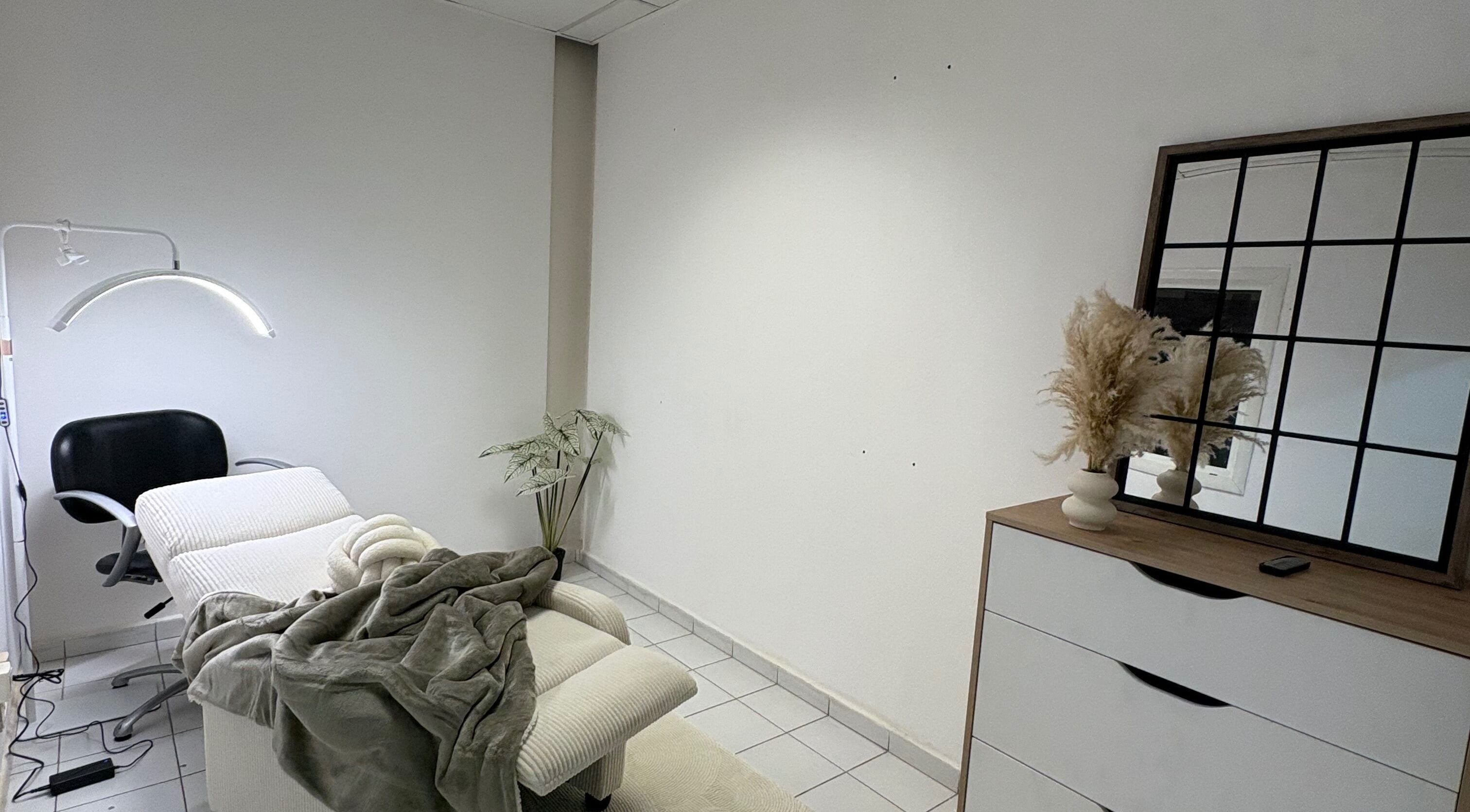 Salle de soins reposante à Kaïa Studio, Les Abymes, GP, avec table de massage et déco apaisante.