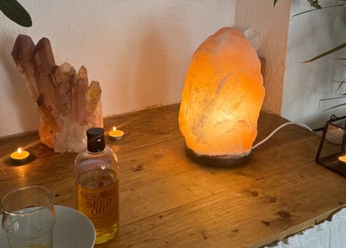 Tranquil setup at Slow Down, Brighton And Hove, England, GB with salt lamp, crystals, and sesame oil.