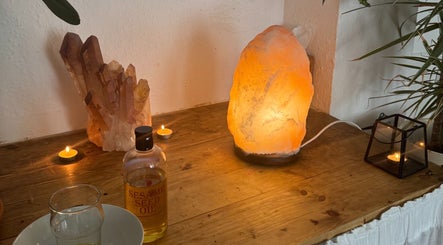 Tranquil setup at Slow Down, Brighton And Hove, England, GB with salt lamp, crystals, and sesame oil.