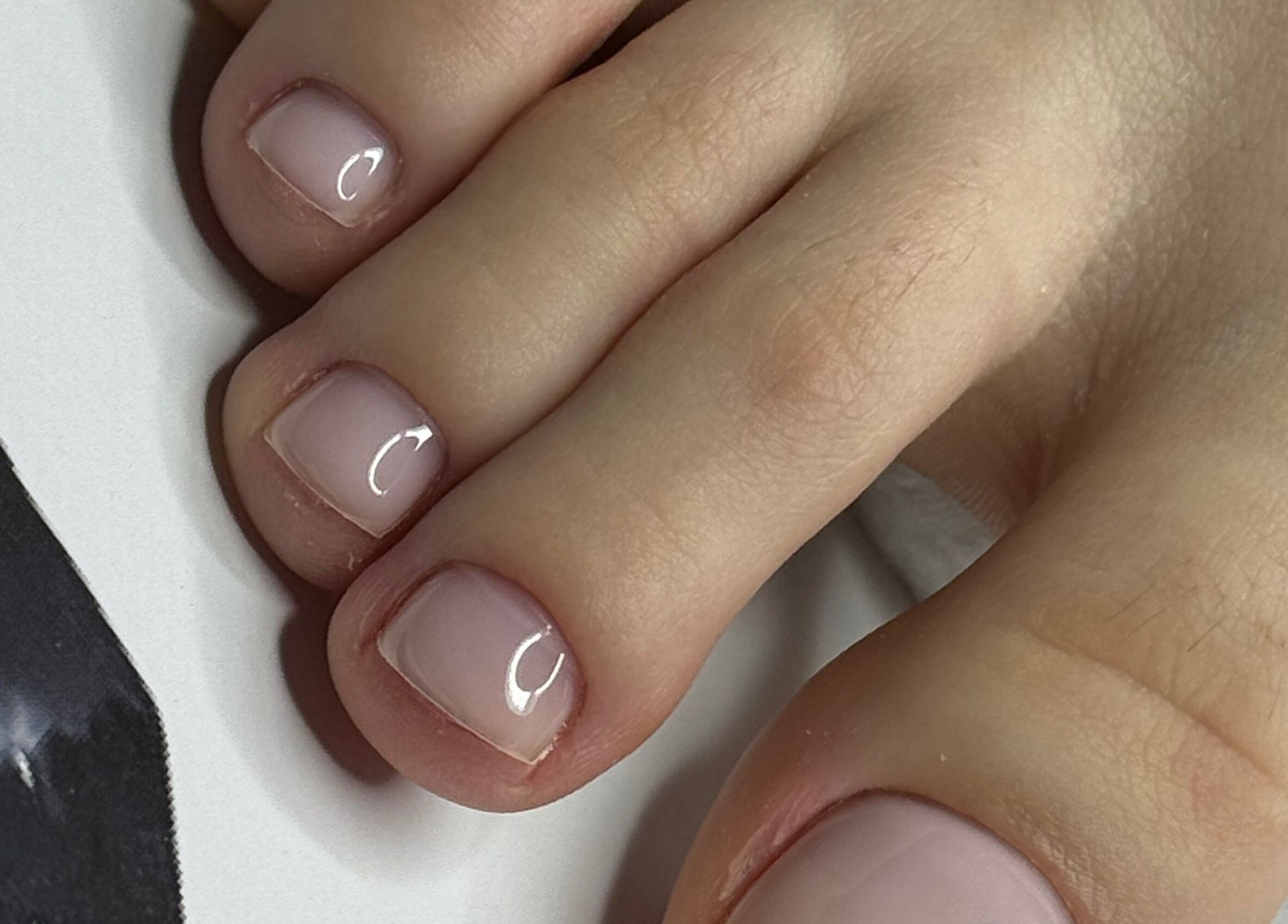 Close-up of glossy toenails at ZInailSTUDIO, Milton Keynes, England, GB. Expert nail care in a serene setting.