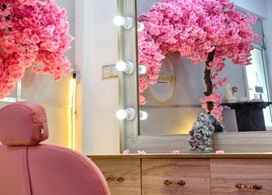 Elegant salon chair and ornate mirror at Salon Robarosiya, Gelioya, Central Province, LK. Pink blossoms adorn the decor.