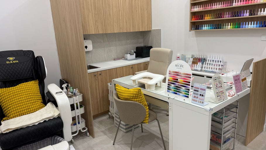 Naily atelier's cozy nail station in West Ryde, New South Wales, AU showcasing vibrant polishes and plush seating.