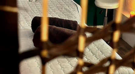 Relaxing massage bed at Healing Touch, Belfast, Northern Ireland featuring cozy brown towels and soothing ambiance.