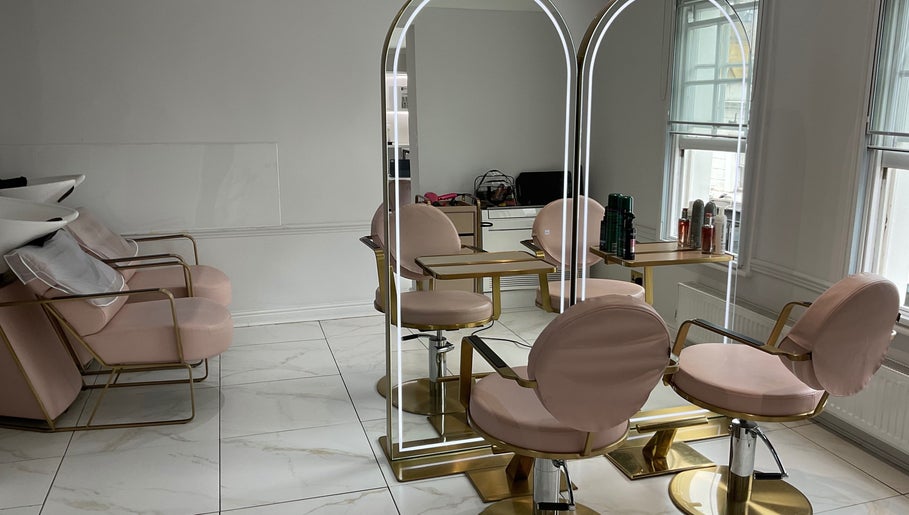 Modern salon interior at Nathalia Militao, London, England, GB with stylish mirrors and pink chairs.