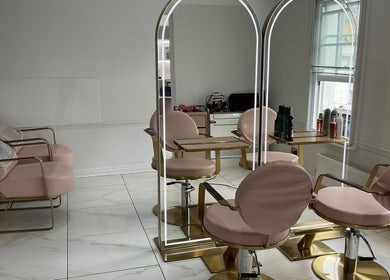 Modern salon interior at Nathalia Militao, London, England, GB with stylish mirrors and pink chairs.