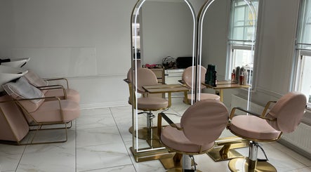 Modern salon interior at Nathalia Militao, London, England, GB with stylish mirrors and pink chairs.