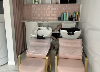 Relaxing hair wash stations at Nathalia Militao in London, England, GB, featuring pink tiles and plush chairs.
