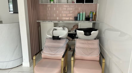 Relaxing hair wash stations at Nathalia Militao in London, England, GB, featuring pink tiles and plush chairs.