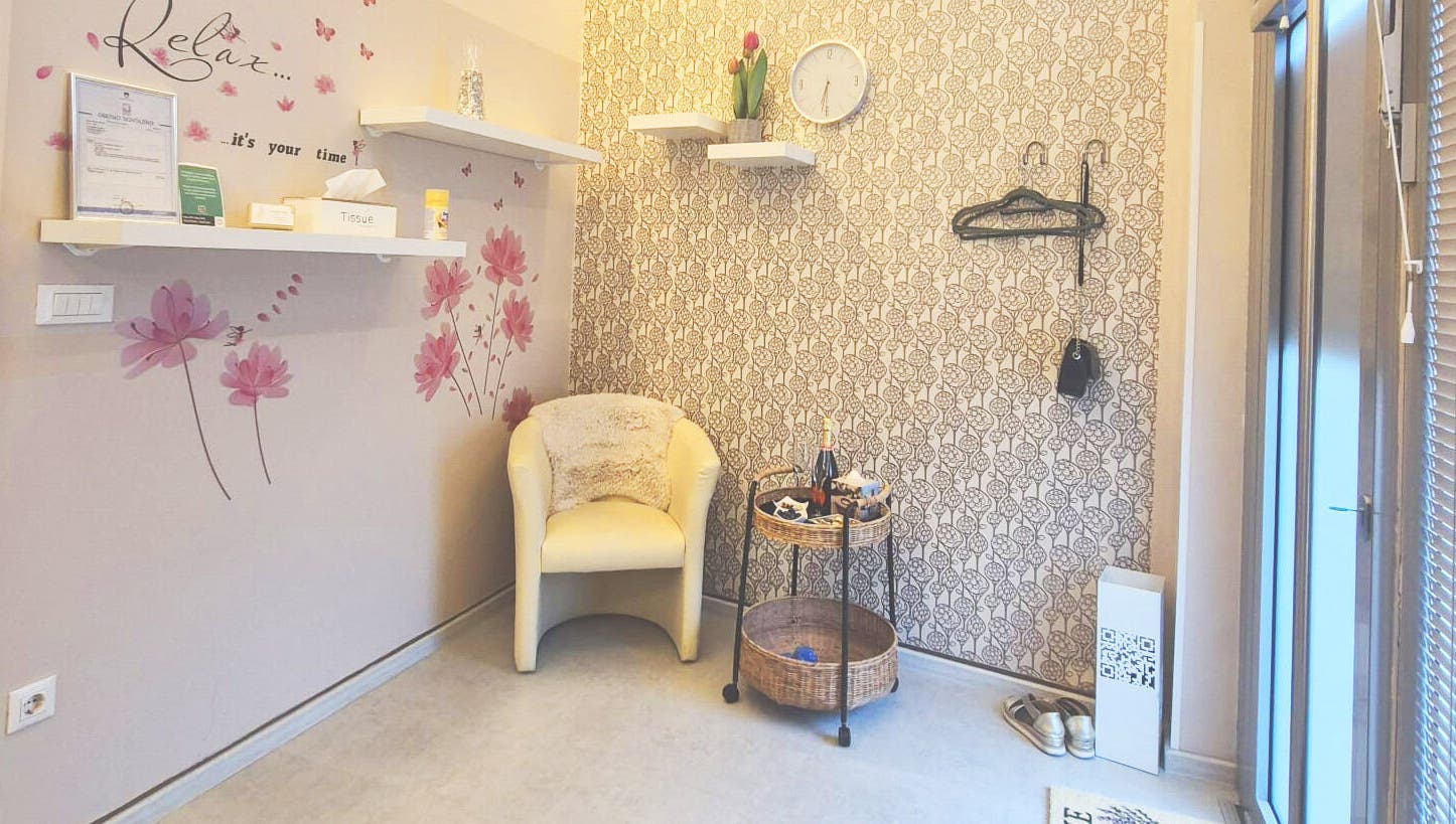 Pogled na čakalni kotiček v Beauty Studio BELLA, Ljubljana, Ljubljana, SI s stilsko tapeto in udobnim stolom.