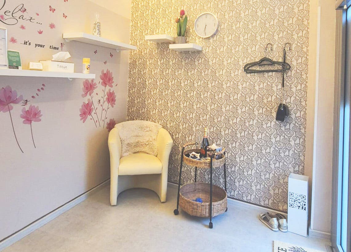 Pogled na čakalni kotiček v Beauty Studio BELLA, Ljubljana, Ljubljana, SI s stilsko tapeto in udobnim stolom.