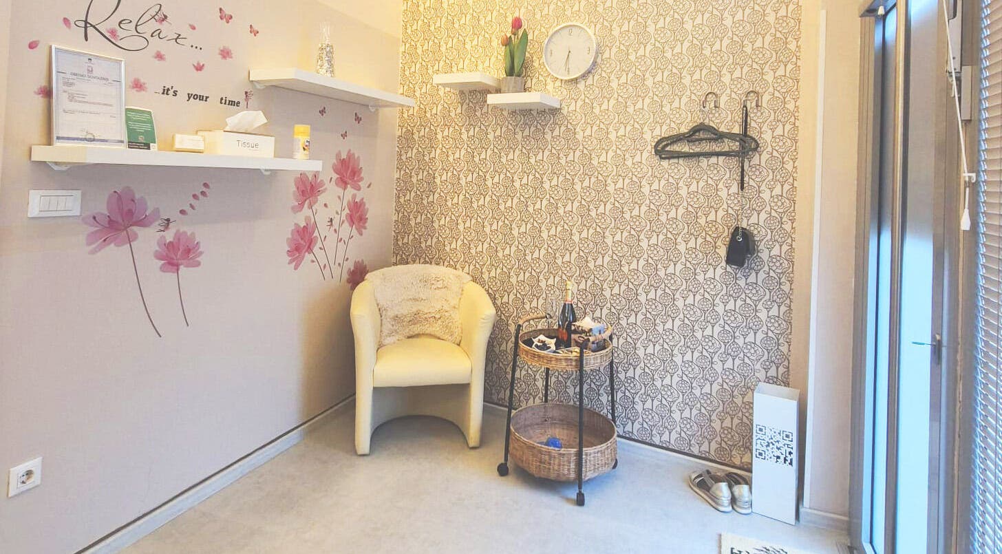 Pogled na čakalni kotiček v Beauty Studio BELLA, Ljubljana, Ljubljana, SI s stilsko tapeto in udobnim stolom.