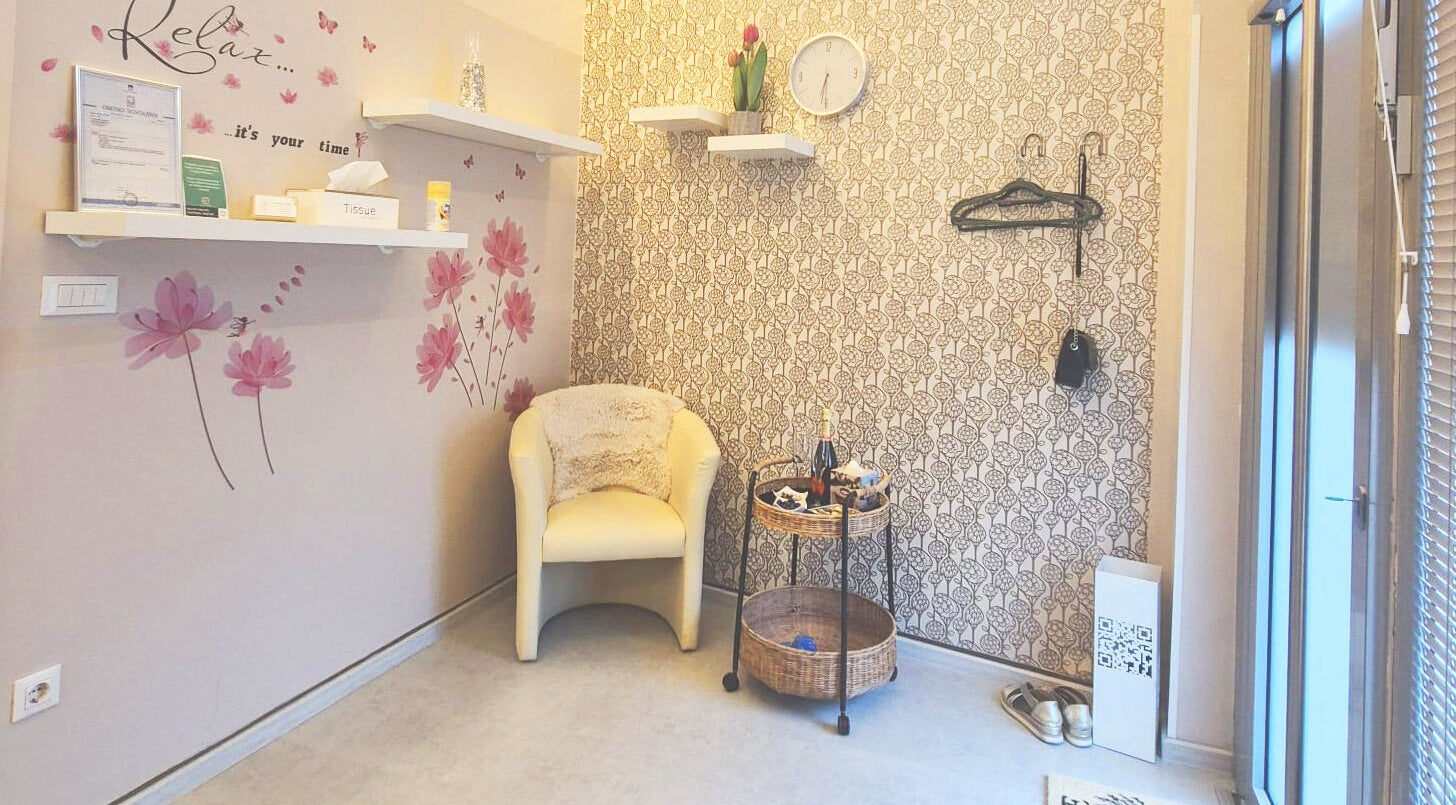 Pogled na čakalni kotiček v Beauty Studio BELLA, Ljubljana, Ljubljana, SI s stilsko tapeto in udobnim stolom.