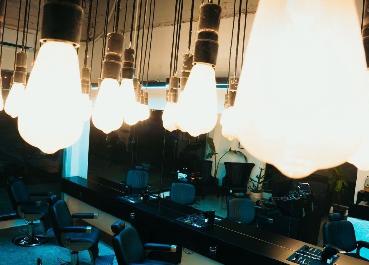 Bright salon interior at HANOSA, Ismailia Governorate, EG with stylish chairs and glowing hanging lights.