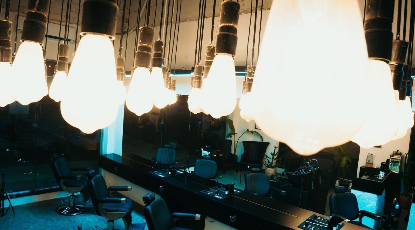 Bright salon interior at HANOSA, Ismailia Governorate, EG with stylish chairs and glowing hanging lights.